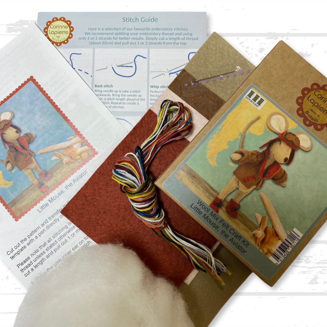 Contents of the aviator felt craft kit, including packaging, felt pieces, embroidery floss, toy filling, needle, and instruction booklet