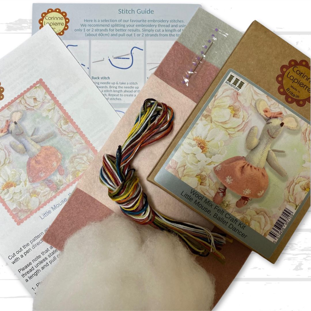 Contents of the ballet dancer felt craft kit, including packaging, felt pieces, embroidery floss, toy filling, needle, and instruction booklet