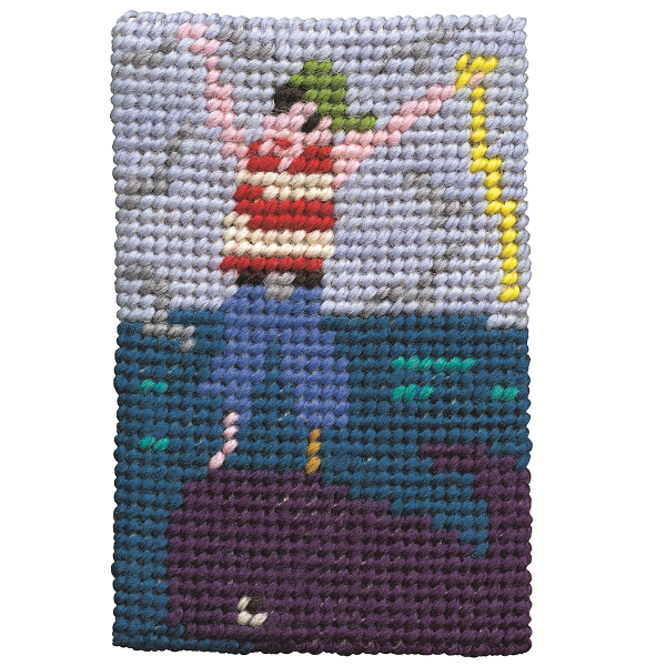 Close-up of completed pirate tapestry kit on blue background