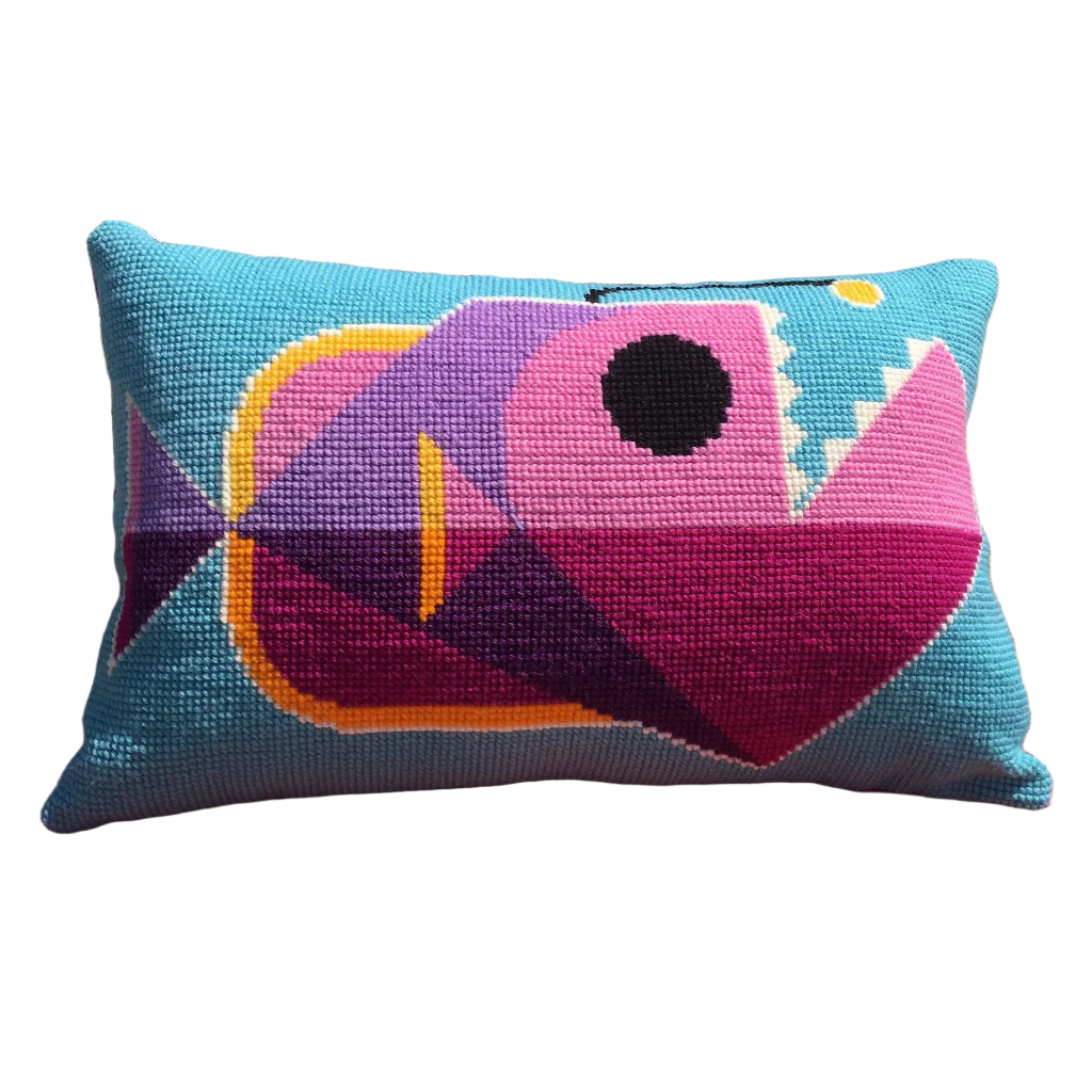 Cross stitch cushion with a quirky anglerfish design in blue, pink and purple