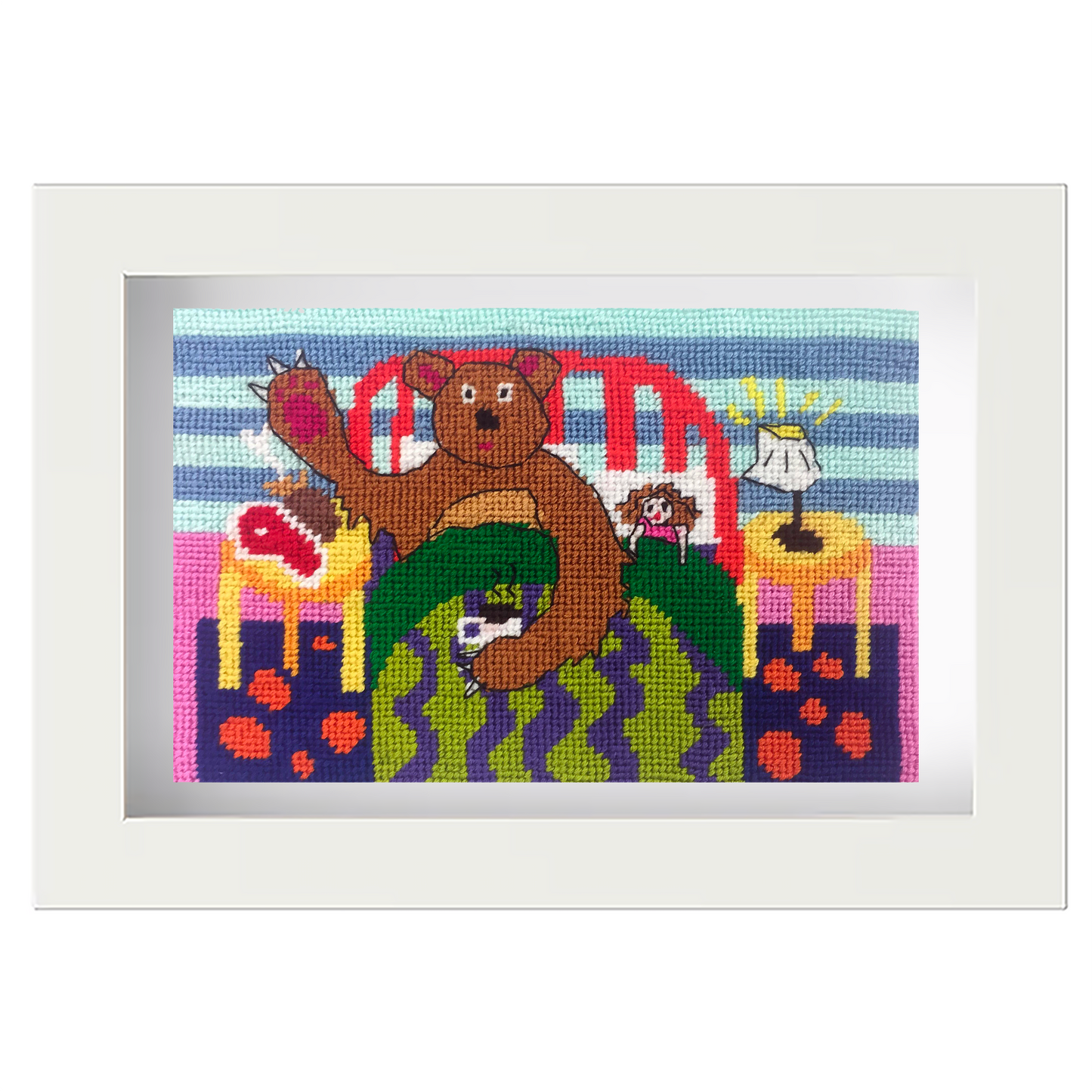 Framed needlepoint with a colourful scene of a bear and toys on a patterned background