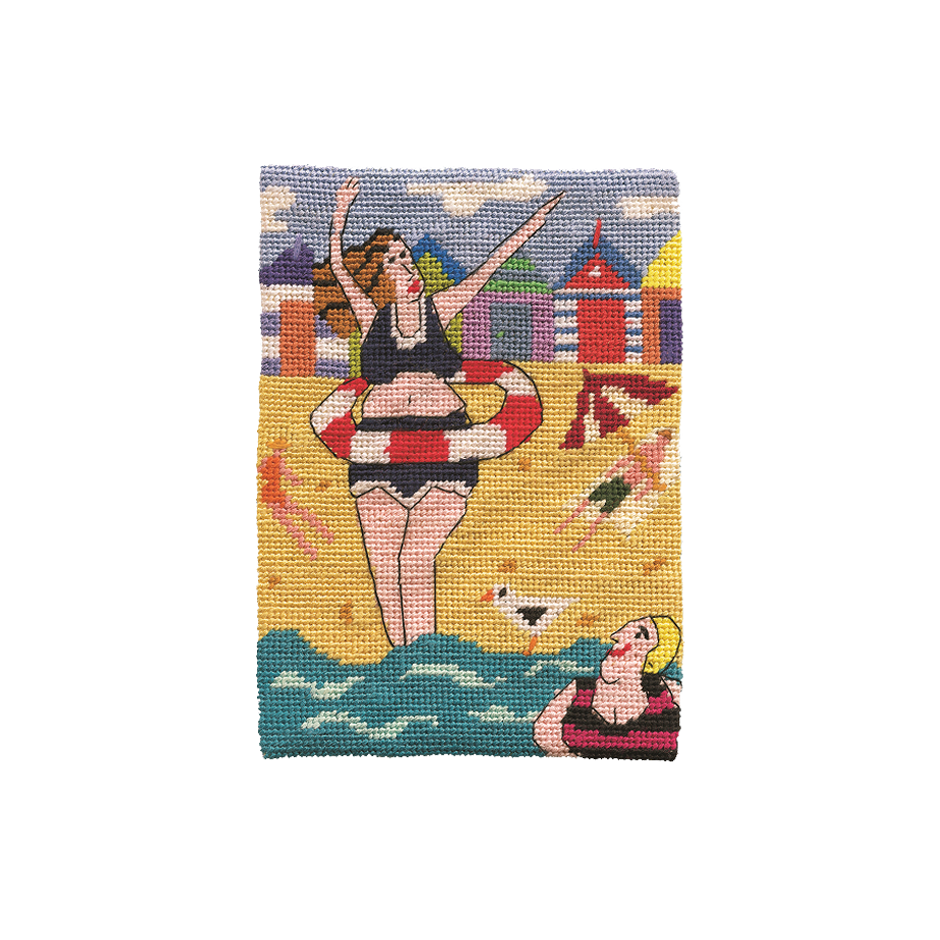  Needlepoint of women in swimsuits with a beach scene background, featuring cabins and a seagull