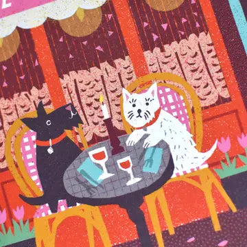 Close-up of an illustrated card featuring Café de l'Amour, with café curtains and two dogs sitting at a table outside