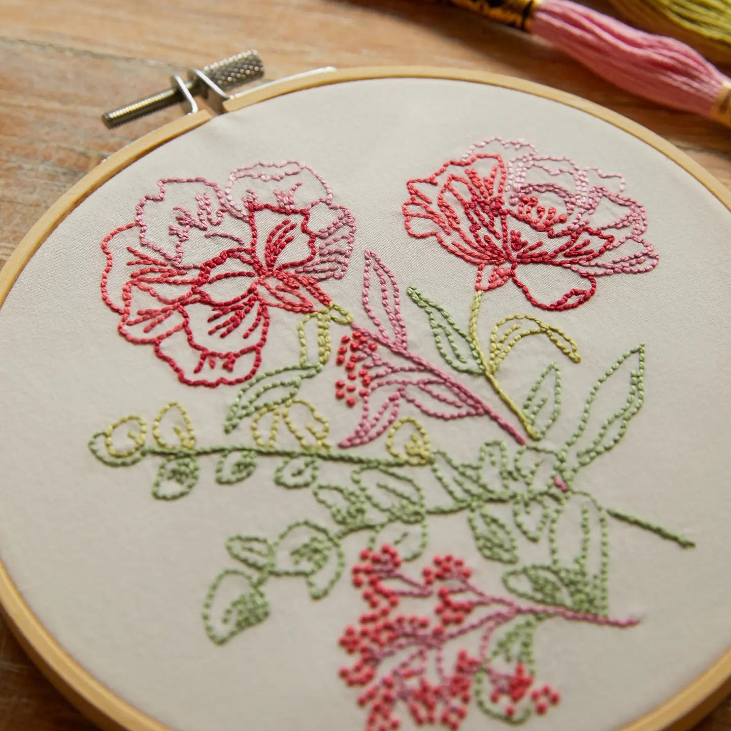 Embroidery hoop with floral design on a wooden surface