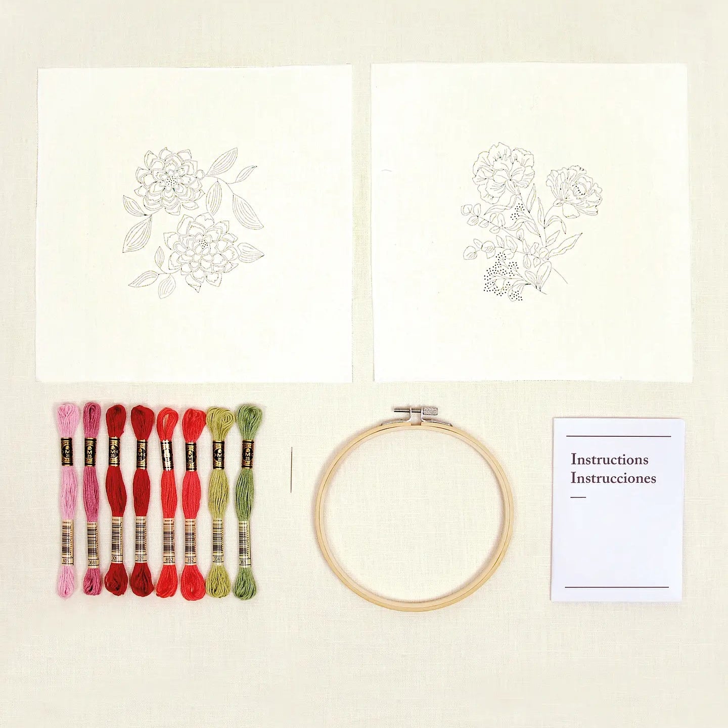 Floral embroidery kit with printed designs, threads, hoop, and instructions on a white background