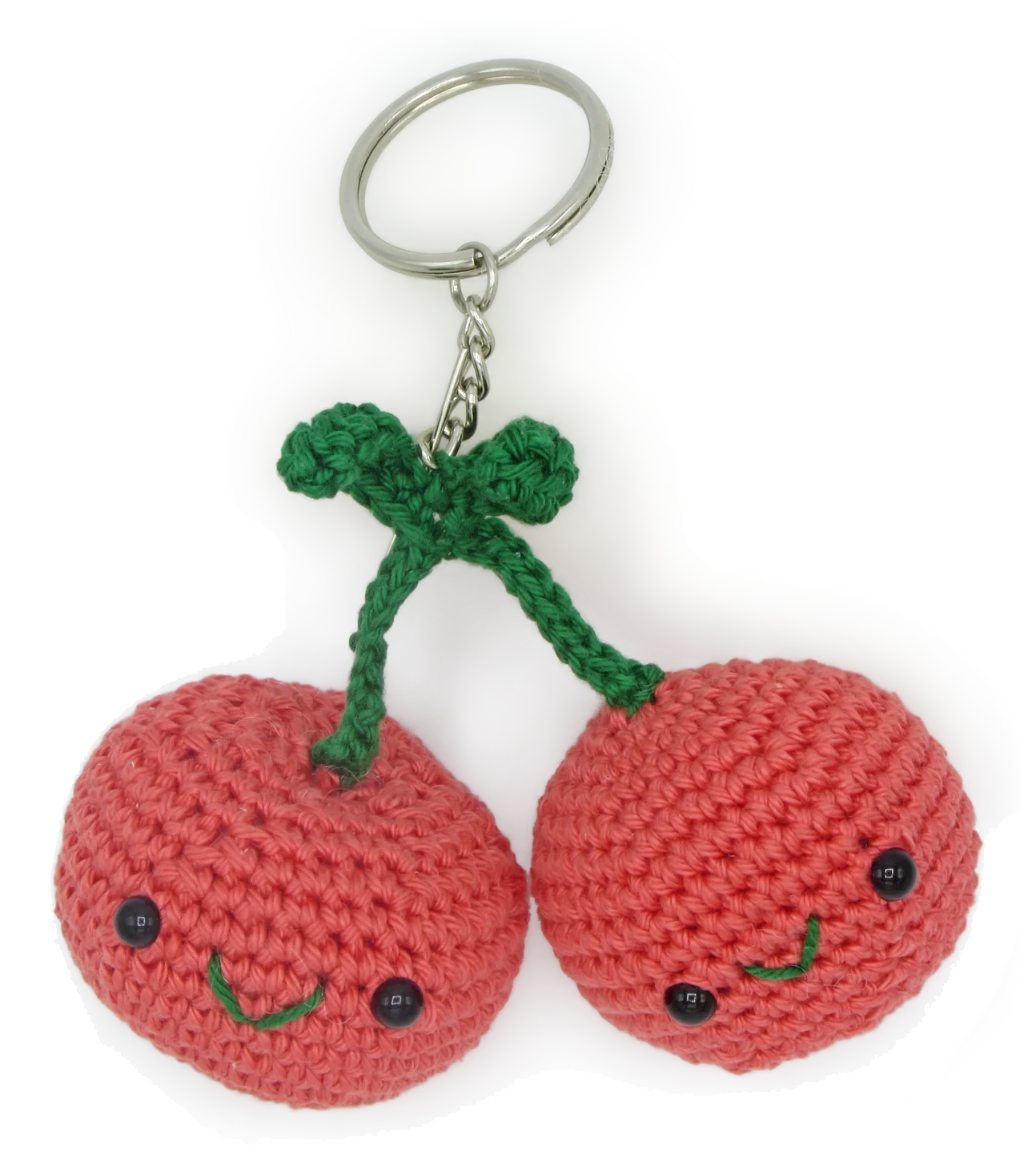 Crocheted cherries keychain or bag charm in shades of red and green on a white background