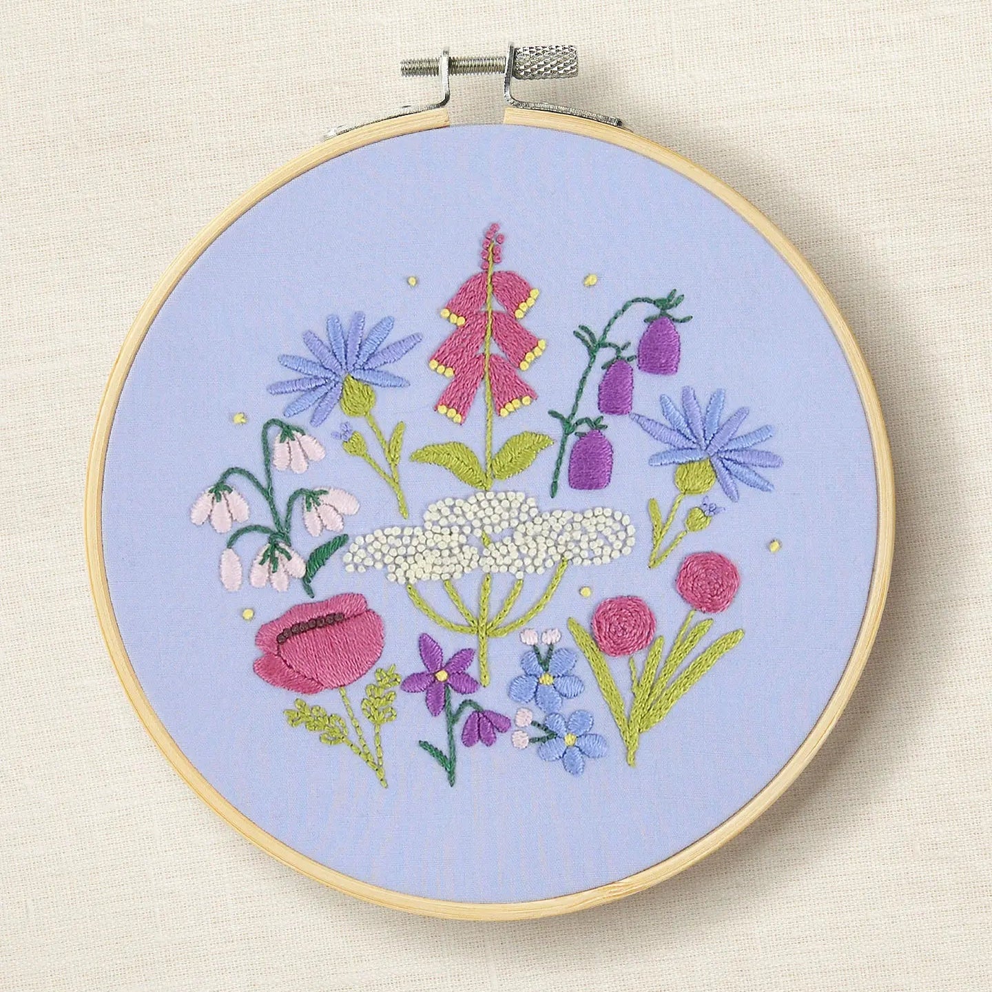 Embroidery hoop with floral design on a light blue background