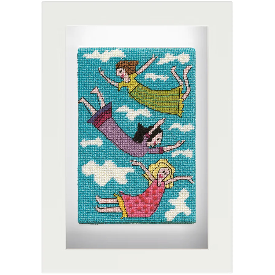 Needlepoint postcard of three women in brightly coloured frocks floating in the clouds on a sky blue background, framed in white