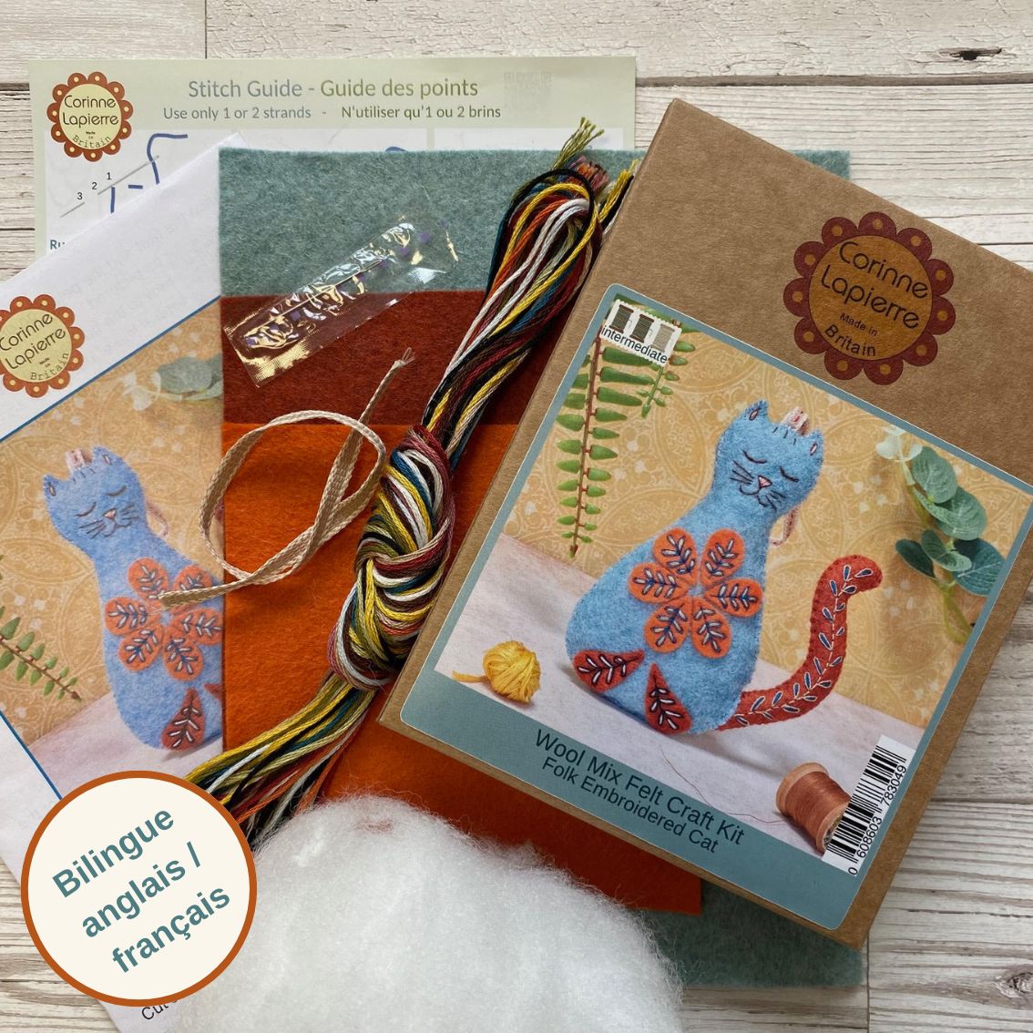 Contents of the folk embroidered felt craft kit, including packaging, felt pieces, embroidery floss, ribbon, toy filling, needle, and instruction booklet