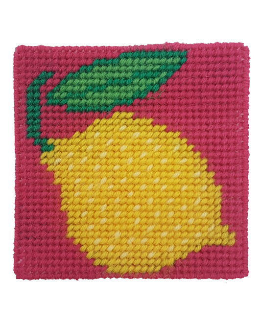 Close-up of a lemon needlepoint design in yellow, green, and pink