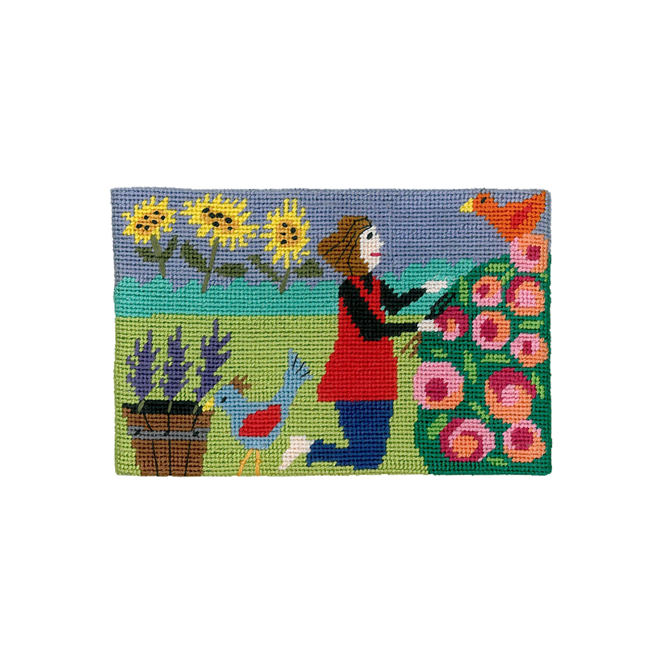 Colourful needlepoint of a woman in a garden with flowers and birds