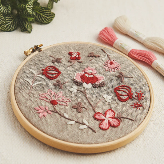Indian Botanical embroidery hoop showing 17th-century inspired florals stitched in warm earthy tones on natural linen fabric