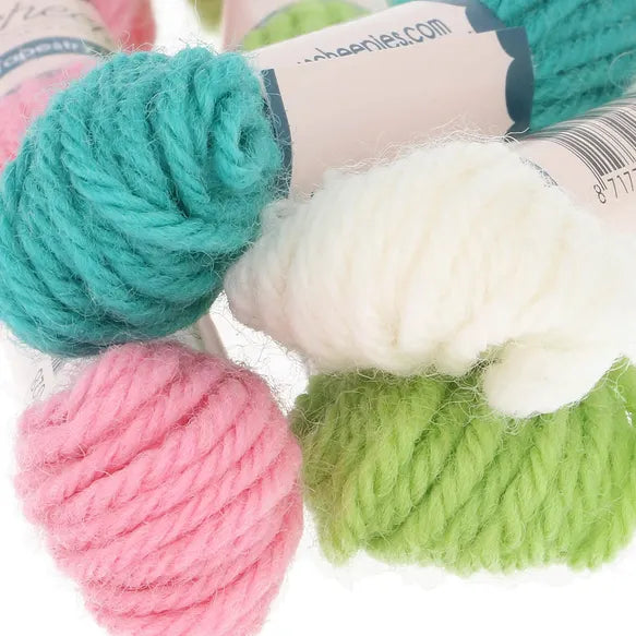 Four skeins of yarn in teal, pink, white, and lime green with brand labels