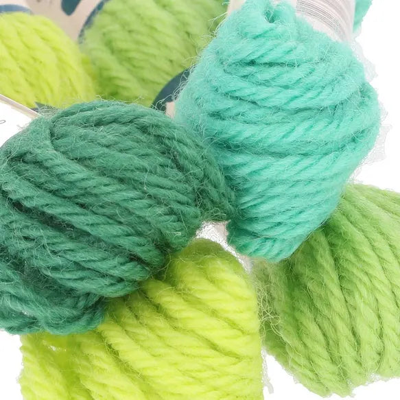 Close-up of green and teal yarn skeins on a white background