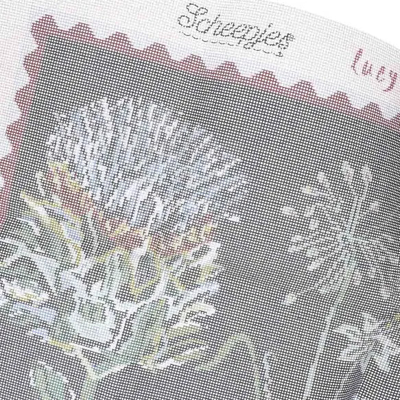 Close-up of a canvas fabric swatch with floral pattern and Scheepjes branding