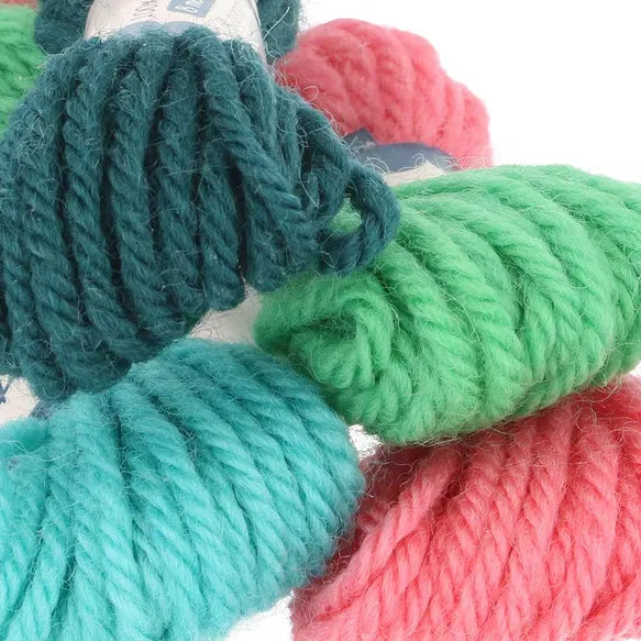 Close-up of colourful yarn skeins in green, pink, and blue