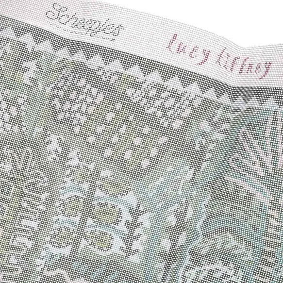 Close-up of printed, textured canvas fabric with Lucy Tiffney branding and patterned design