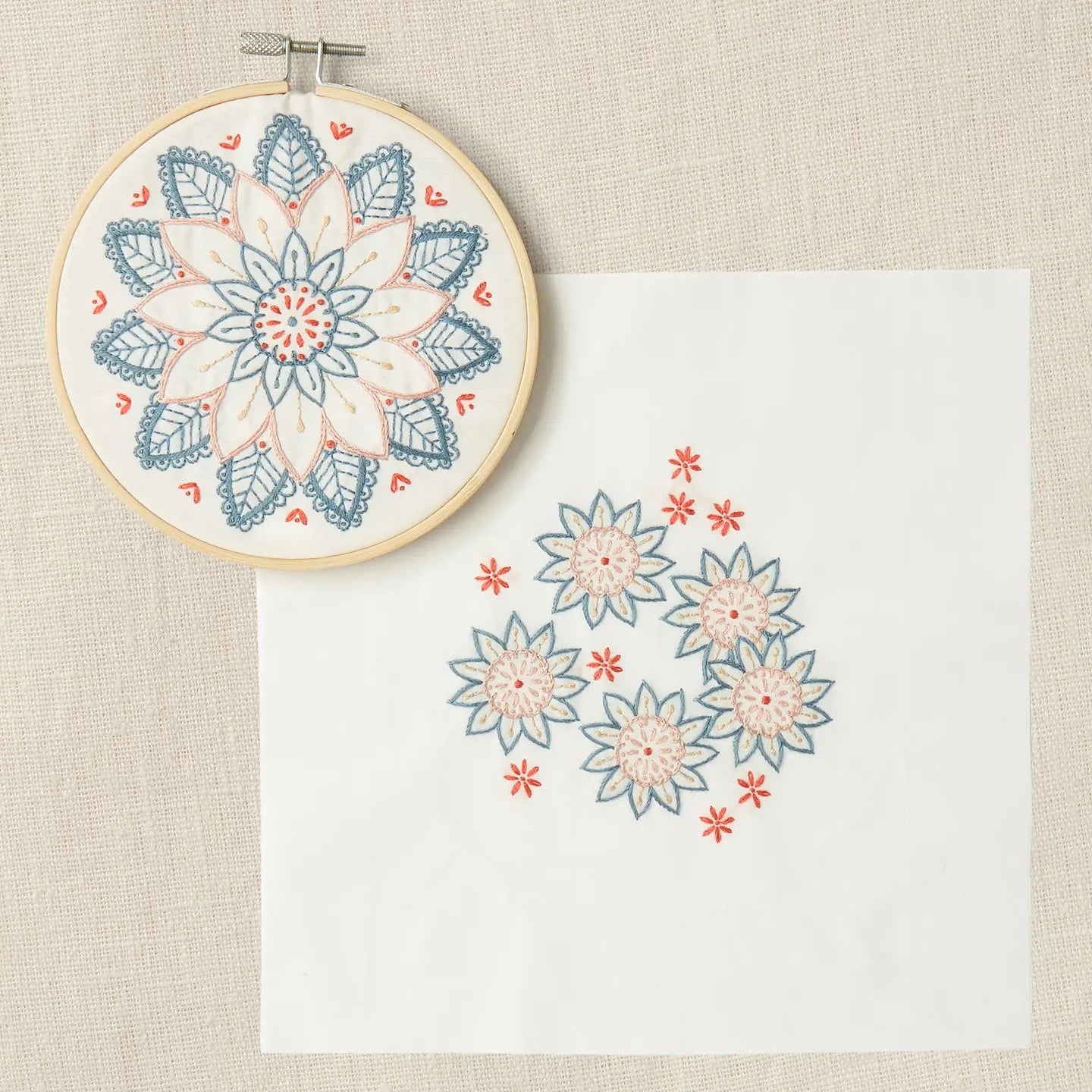 Embroidery hoop with  completed mandala and coordinating design on a cream background