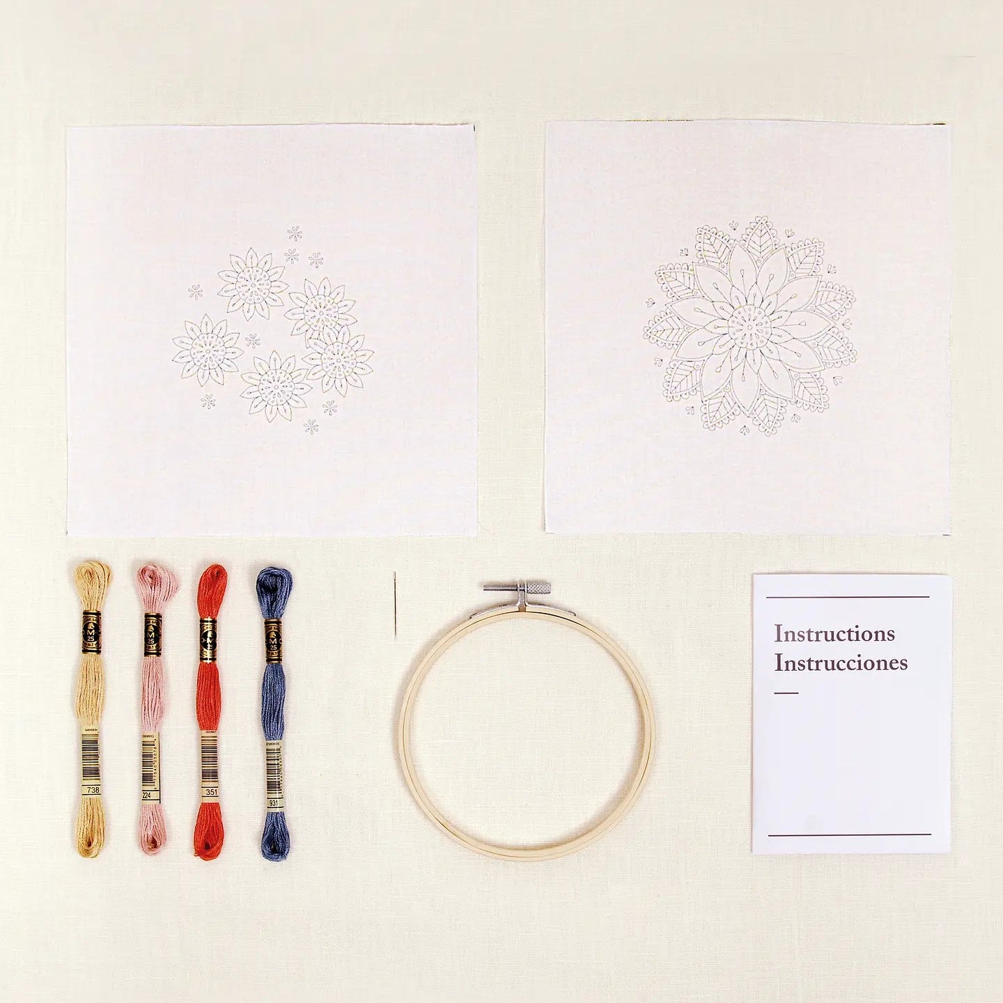 Embroidery kit with printed designs, hoop, threads, and instructions on a light background