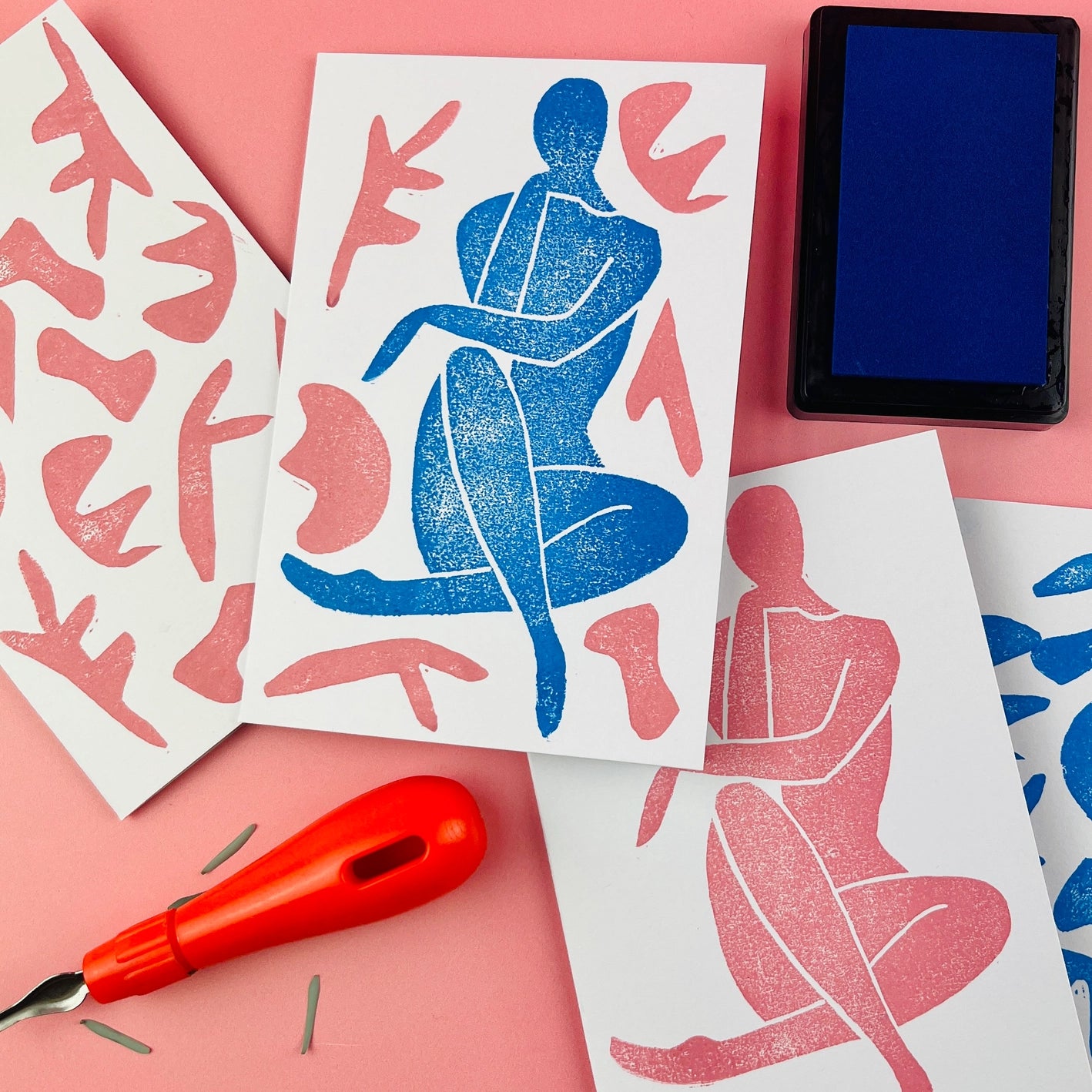 Matisse-inspired lino print card in shades of blue and pink with print tools in background