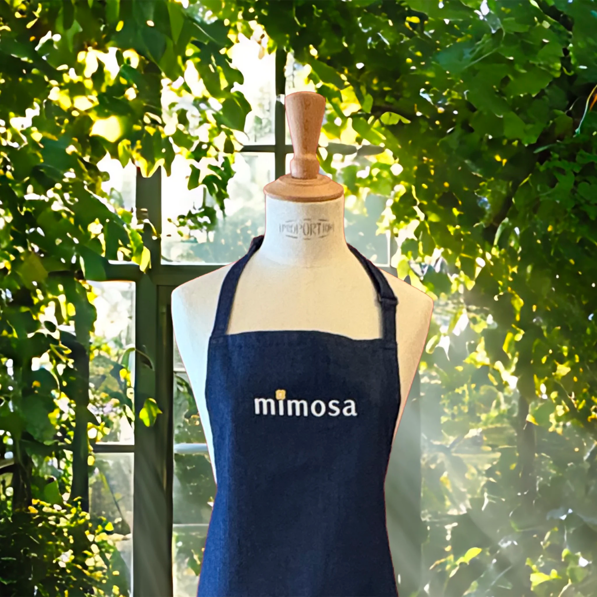 Close up of Mimosa denim apron showing self-fabric neck loop with sliding, adjustable buckle