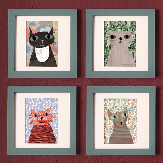 A set of four framed prints featuring delightful cat illustrations on different floral patterned backgrounds, displayed on a wall