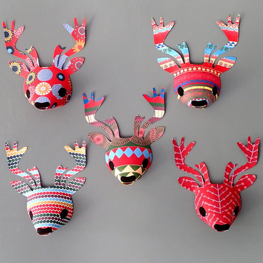 A set of five colourful reindeer wall decorations with antlers in various bright colours, displayed on a grey wall background