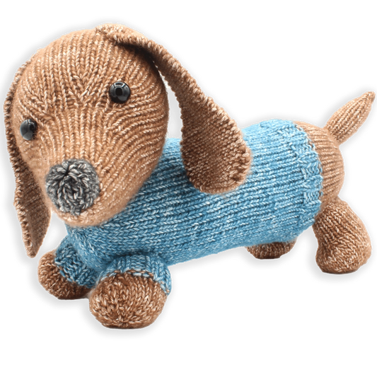 A knitted dachshund dog toy with black eyes and nose, and a blue sweater, on a white background